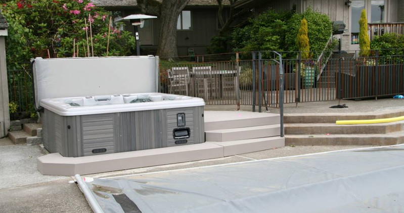 Beautiful custom backyard builds by Decks and Spas featuring deck and hot tub, privacy screen, BBQ centers, and firepits. Composite decking. Located in Redmond, Serving the Eastside, and Greater Seattle.