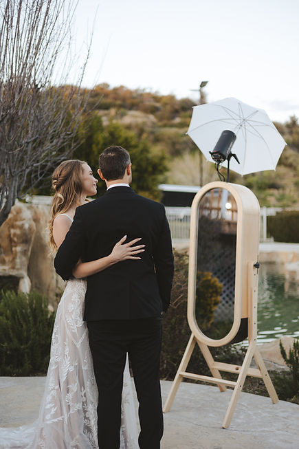 bride and groom taking a picture with retro mirror photo booth