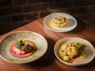 three plates of food on a wooded table