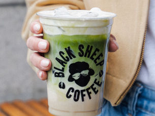 an iced matcha latte in a lady's hand
