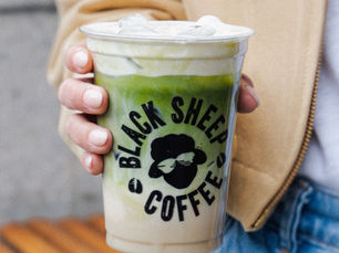 an iced matcha latte in a lady's hand