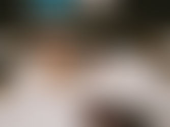 two ladies toasting champagne on a bed