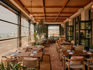 tables and chairs in a restaurant overlooking the sea