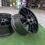 الصورة المصغرة: Several black car wheels, RAYS HOMURA 2x7, set on green grass background, wheels B and B.