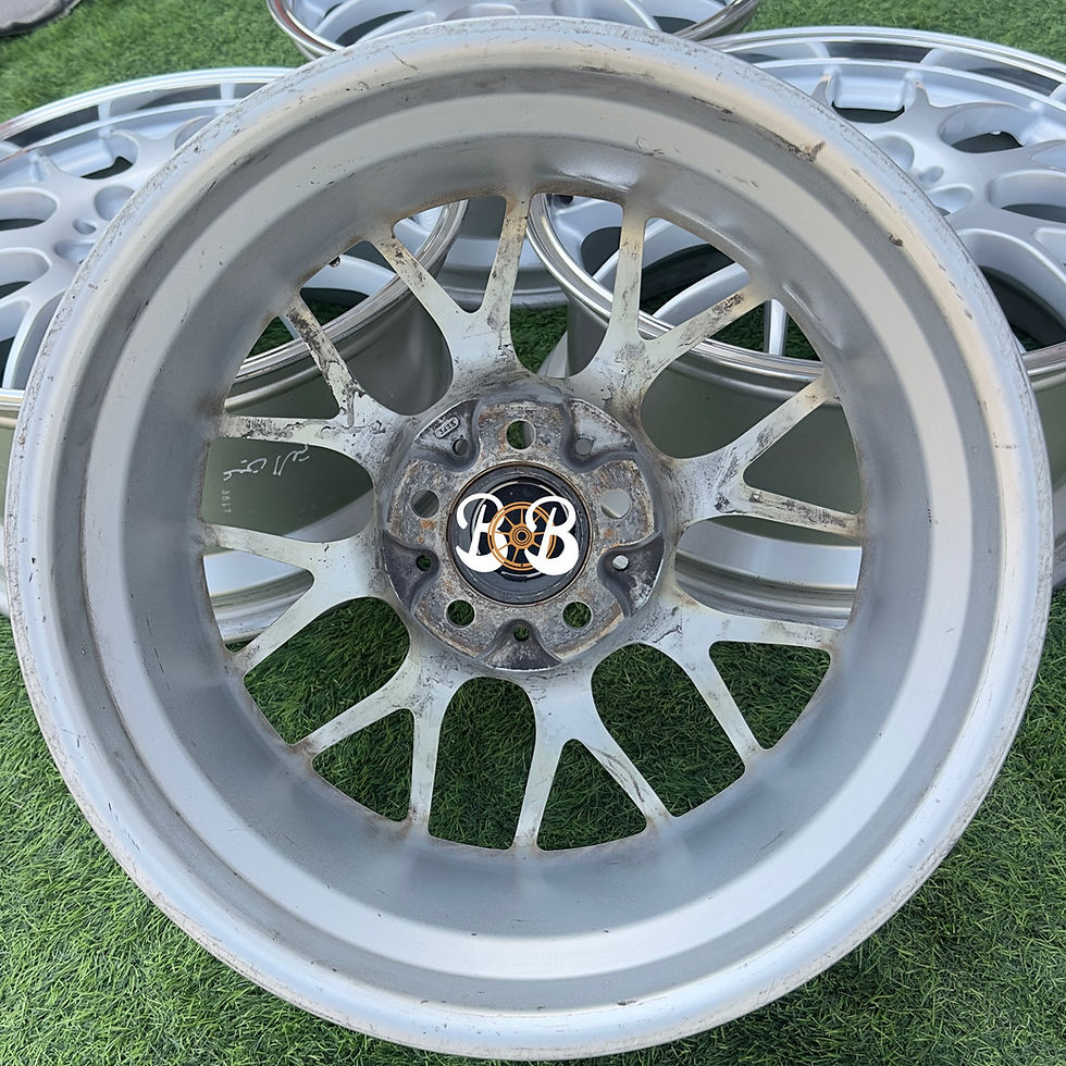 الصورة المصغرة: Silver wheel close-up featuring B and B logo with other wheels in view.