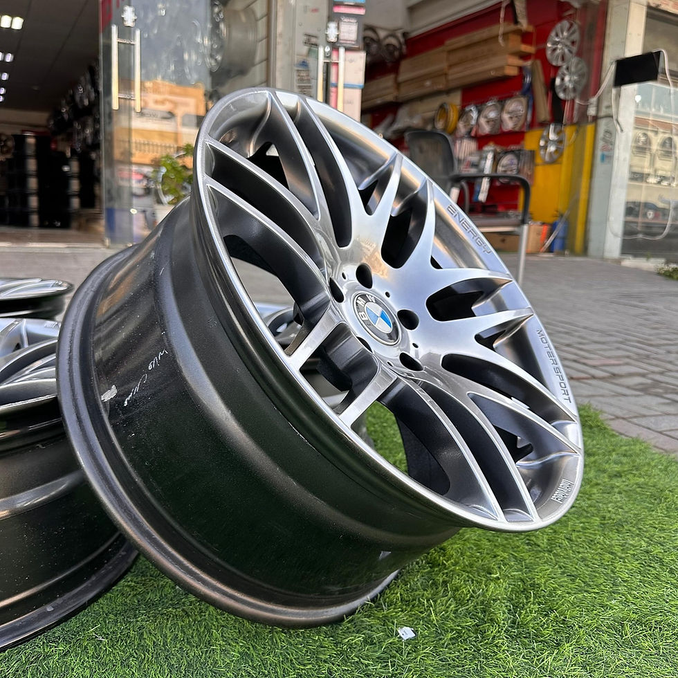 الصورة المصغرة: Close up of a silver and black car wheel, on display. wheels B and B.