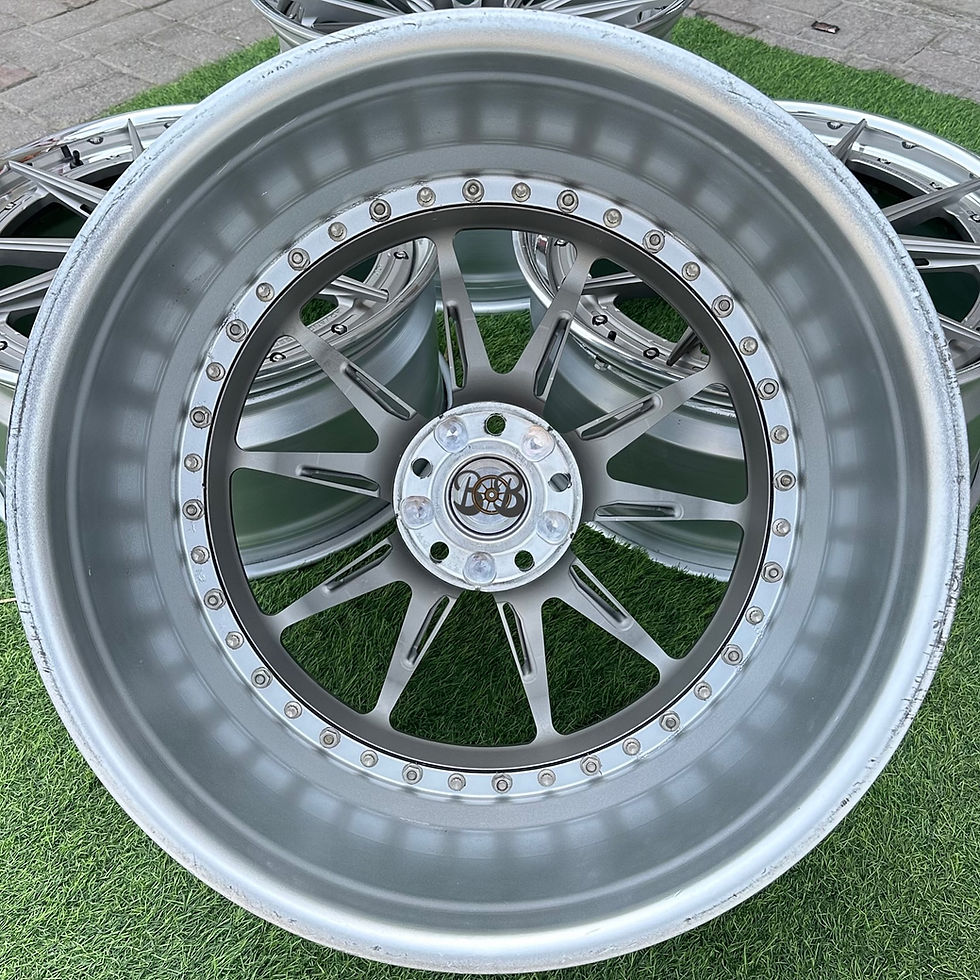 الصورة المصغرة: Silver alloy wheels with the logo B and B, on grass, close up