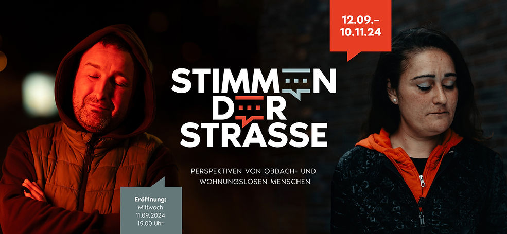 Ein spanisches Paar ist auf diesem Farbbild. Ein Mann und eine Frau, die in Berlin obdachlos sind. In der Mitte steht der Titel der Ausstellung: Stimmen der Straße.