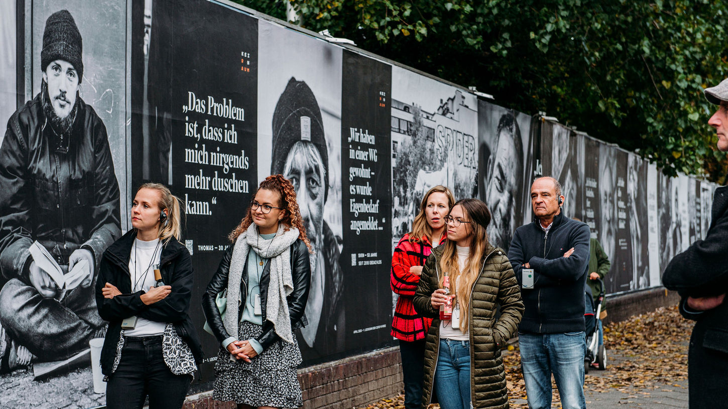 Menschen besuchen die Outdoor-Ausstellung zum Thema Obdachlosigkeit in Berlin, Kreuzberg. KEIN RAUM - Obdachlos in Zeiten von COVID-19 .