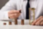 front-view-businessman-with-coins-hourglass.webp