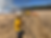 Four workers in yellow coats tending a grassland fire.