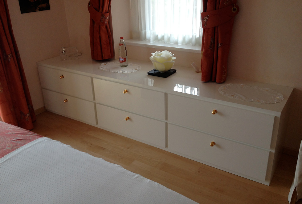 Sideboard Möbel mit Schubladen in Schlafzimmer. Fronten und Sichtteile in Hochglanz weiss lackiert und poliert. Griffe in Messing vergoldet.