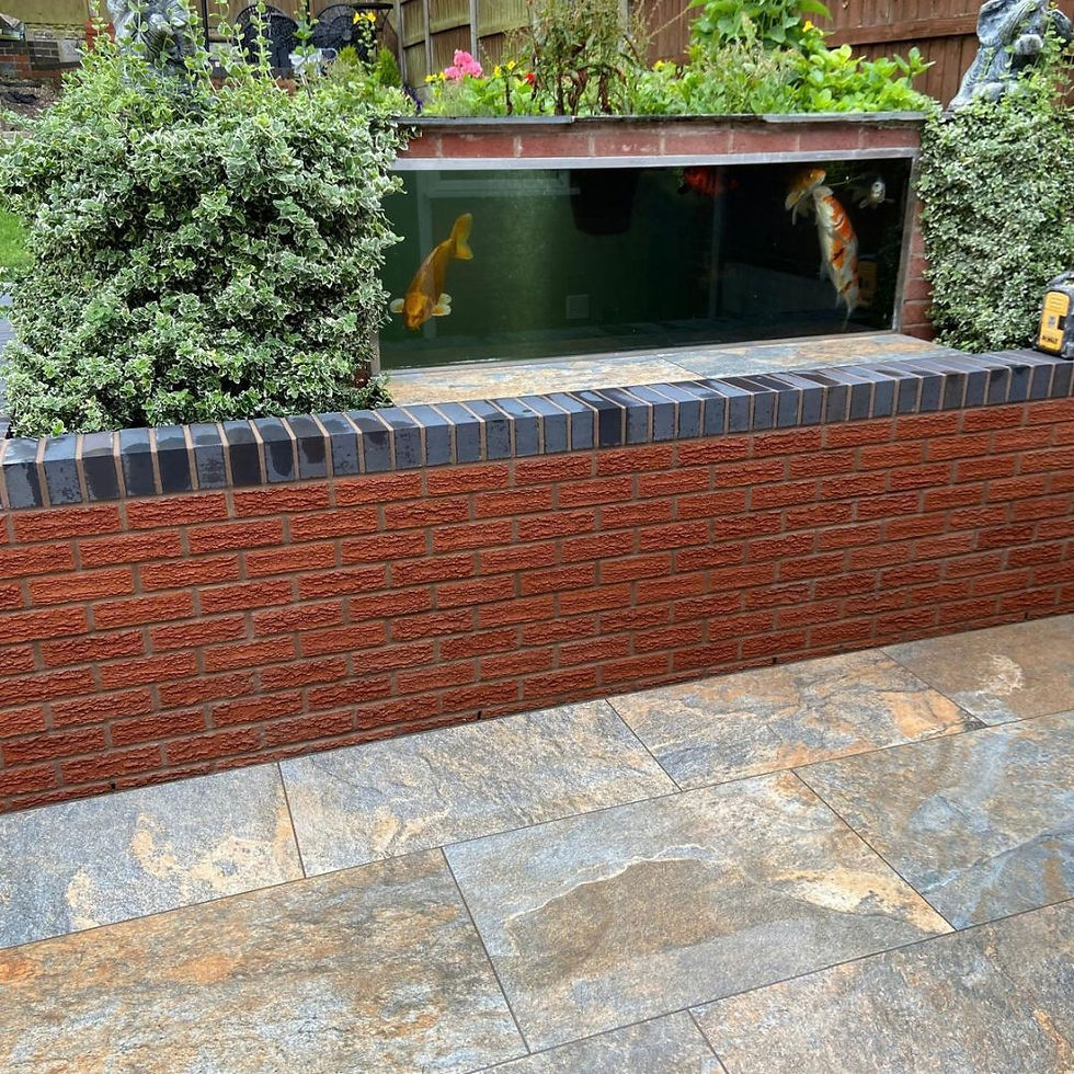 Raised pond and planting feature built into a garden wall with new stone paving, Kidderminster
