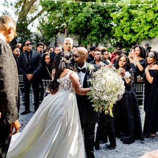 Father of the groom kissing bride on the cheek.
