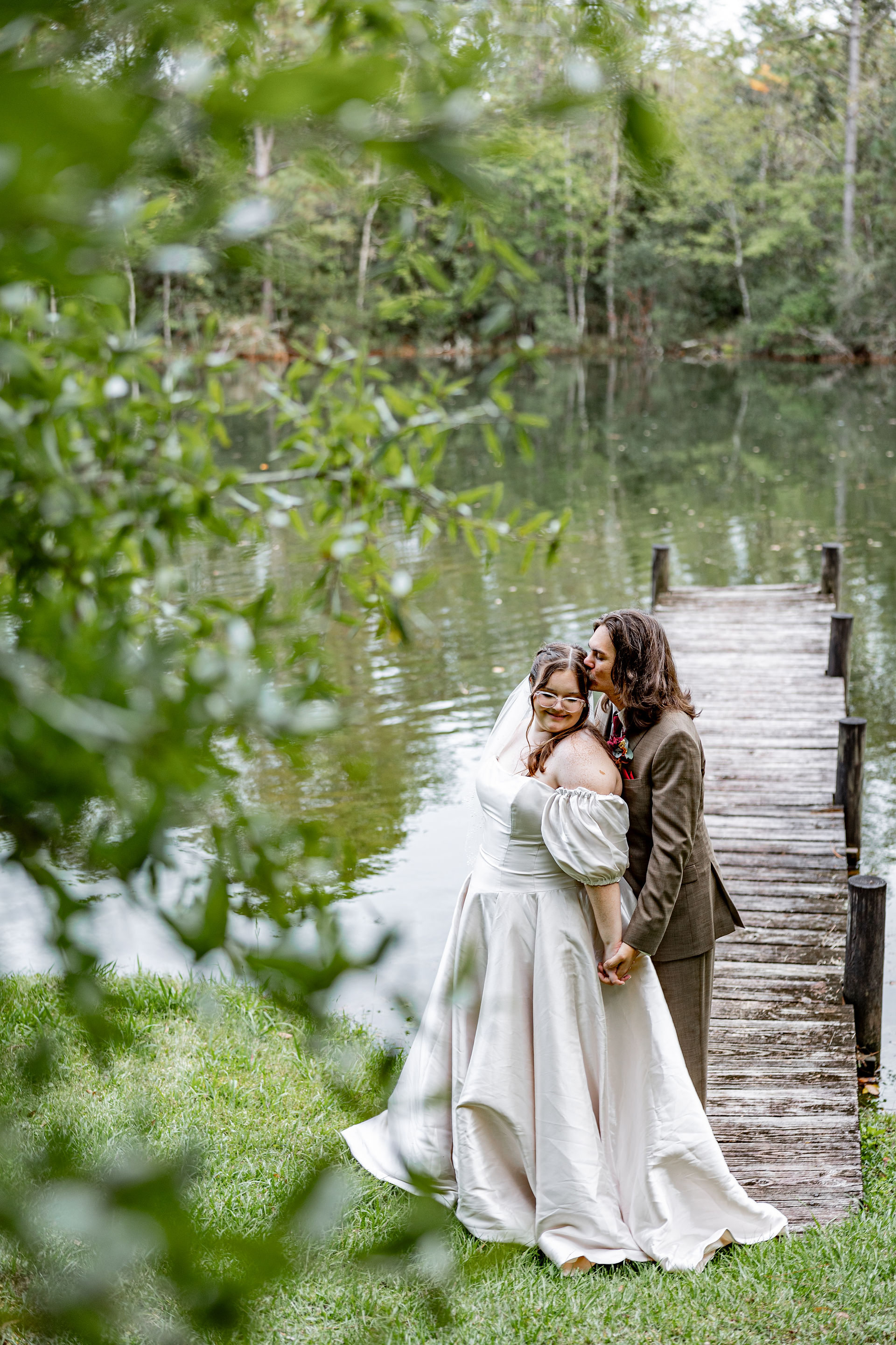 Bride and groom standing by lake