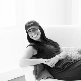 The author, Lisa Mitchell sitting in a chair and smiling