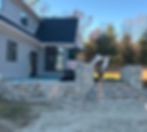 Excavator working on stone patio and steps construction.