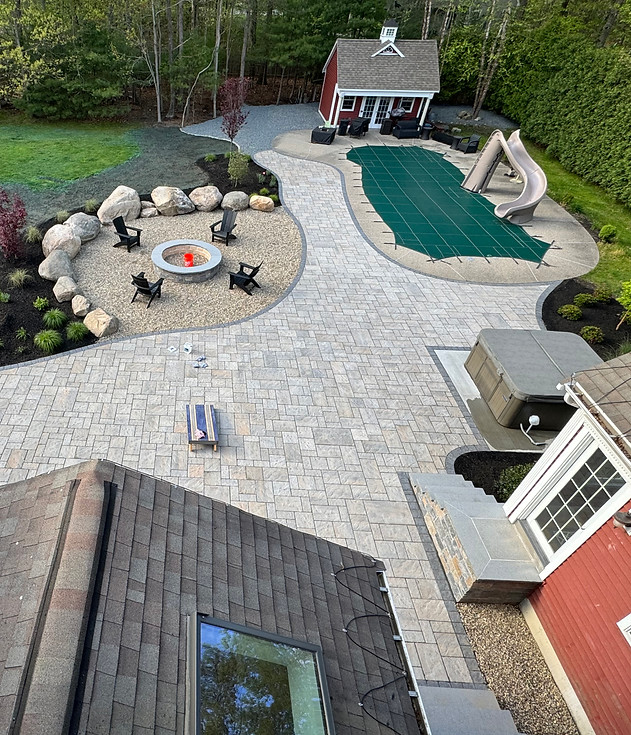 Aerial view of hardscape patio with fire pit and pool.