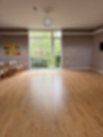 A room with wooden floor and large window overlooking the Quiet Garden