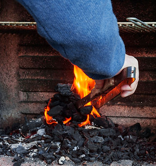 close-up-man-s-hand-burning-coal-barbecue.jpg