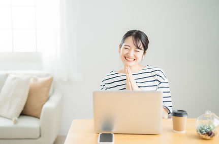 パソコンの前で喜ぶ女性