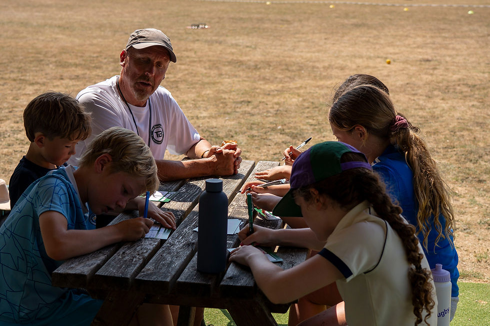 children-completing-cricket-feedback-cards-with-their-coach.jpg