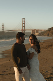 Pregnant woman standing on the shoreline during a maternity beach session