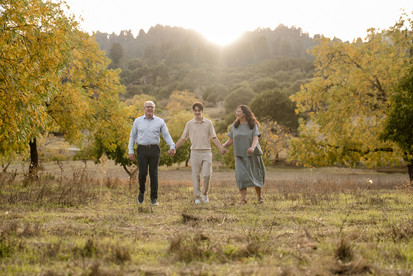 Candid family moments captured outside, with natural light and greenery in the background