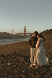 Pregnant woman standing on the shoreline during a maternity beach session