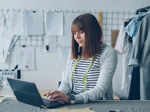 A small business owner researches AEO on her laptop.