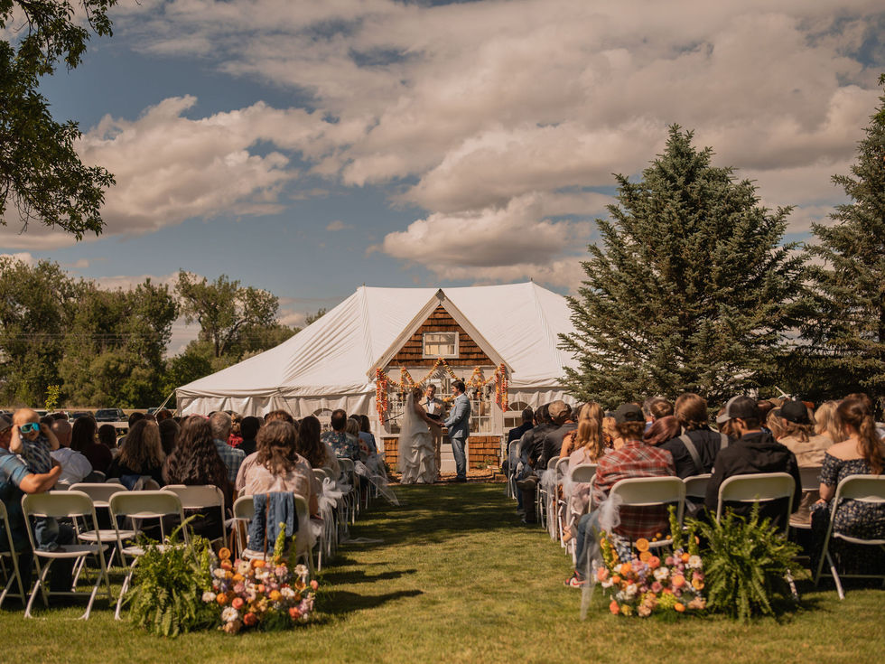 Bright eclectic wedding ceremony featuring playful orange, coral, pink, yellow, white and lime green floral installations