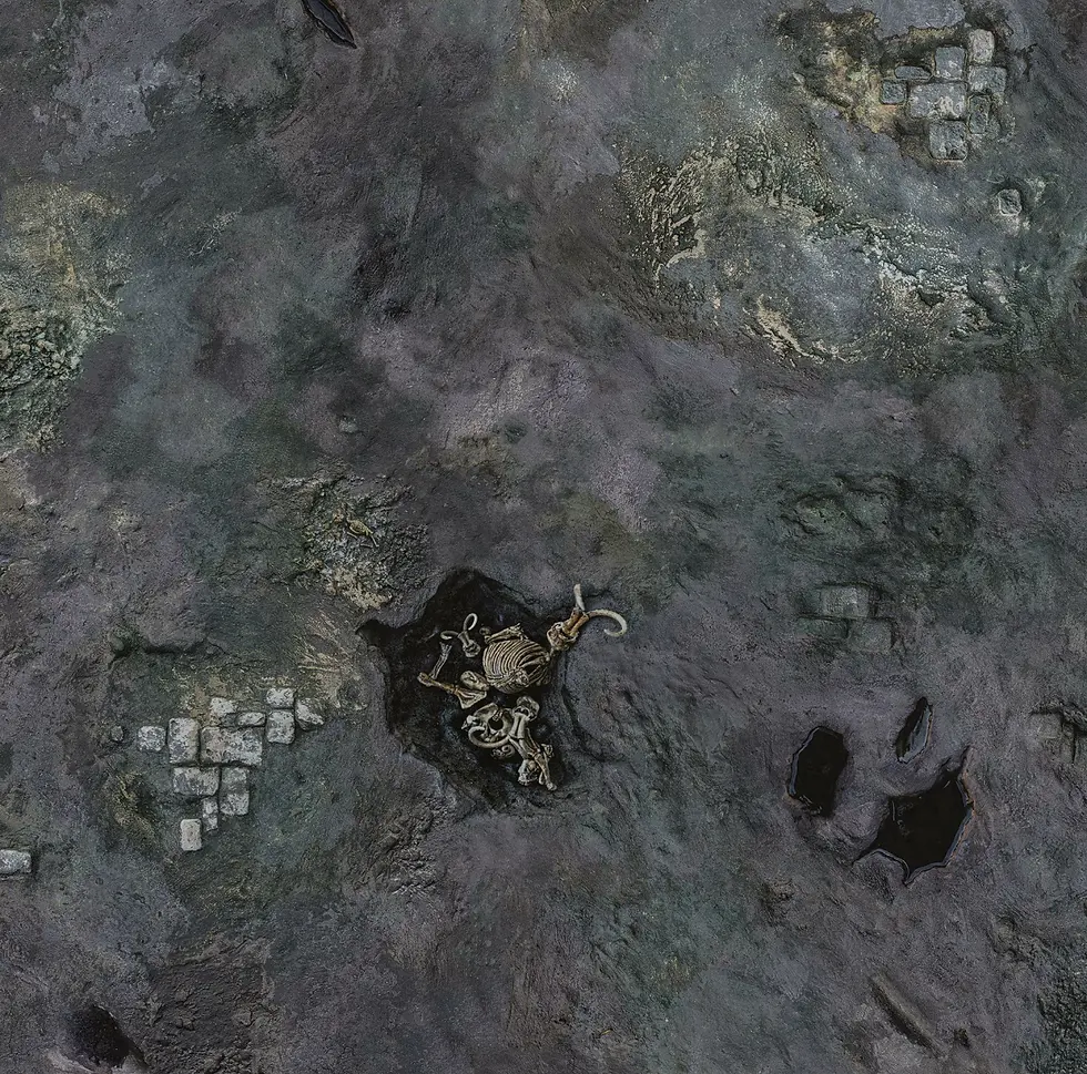 Paesaggio roccioso scuro, grigio visto dall'alto con piccole costruzioni sparse.