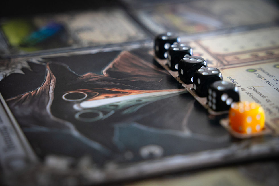 Dadi neri allineati su un tabellone da gioco scuro e illustrato.