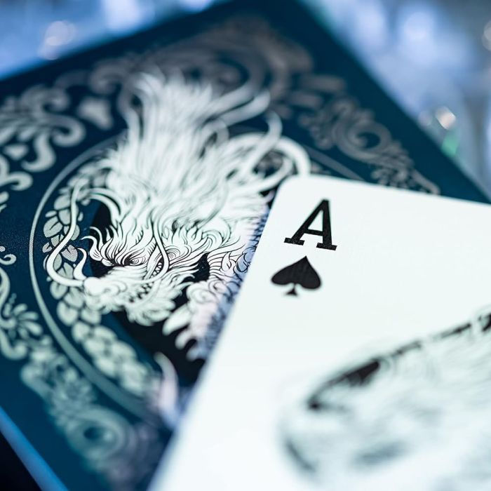 Asso di picche su dorso carta scura con drago argenteo.