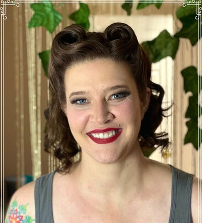 Smiling woman with red lipstick and vintage hairstyle poses, EJS Beauty.