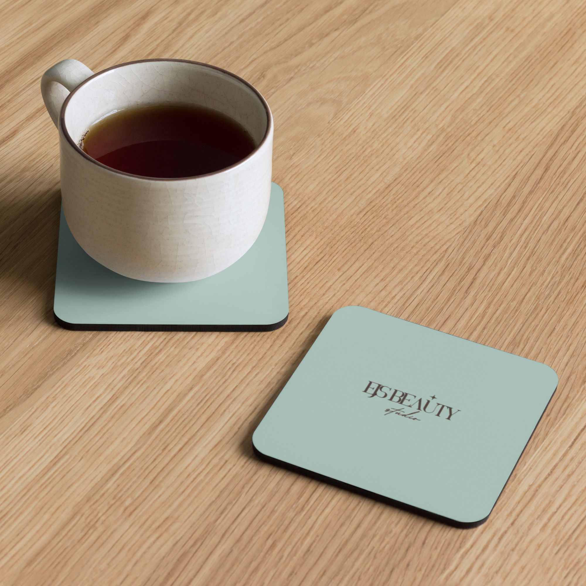 White tea mug on light green HARU HAVEN coasters on wood.
