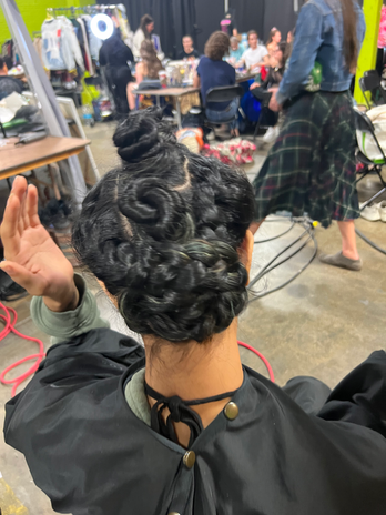 Woman with elaborate braided hairstyle, salon setting, Denver Beauty Salon Services.