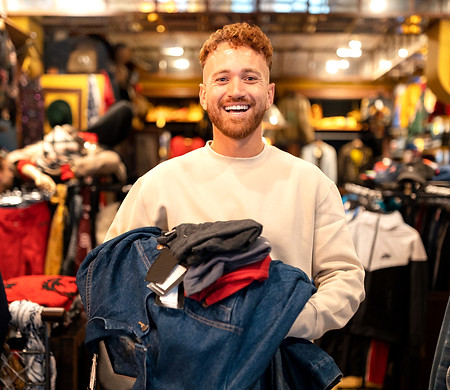 front-view-smiley-man-holding-clothes_ed