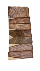 Stacked highly figured lumber with unique grain patterns, ready for woodworking projects.