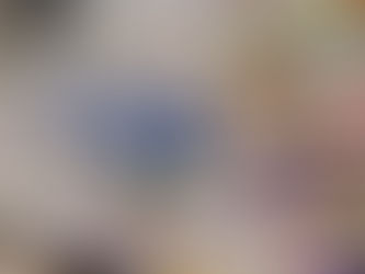 A vibrant splatter painting on white canvas featuring bold blues, purples, yellows, pinks, and oranges created by a couple during their date night experience at Wicked Rae's Splatter Studio in Seattle.