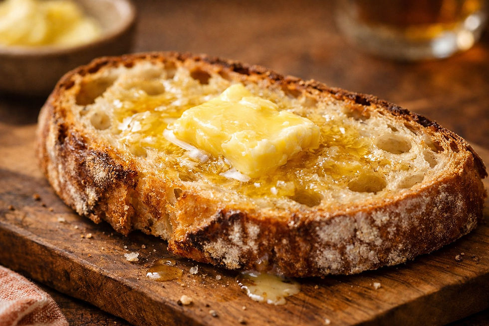 “Close-up of a slice of sourdough bread with melting butter on top, warm natural light, showing carbs as part of a normal, enjoyable diet.”