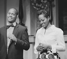 Young man and woman speaking on stage smiling