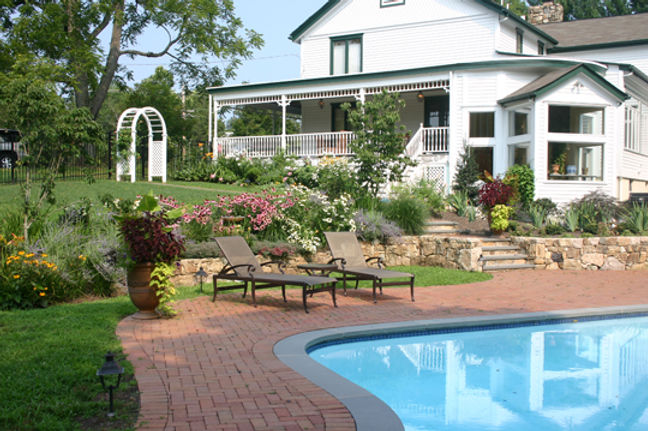 Pool pavers and coping set among backyard planting