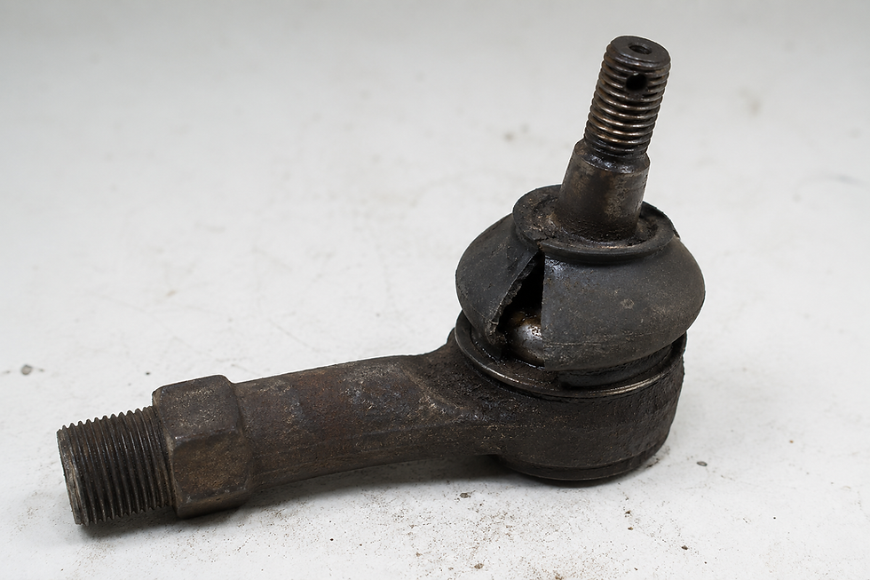 Rusty worn automotive ball joint/tie rod end on white background, with cracked rubber boot and threaded ends.