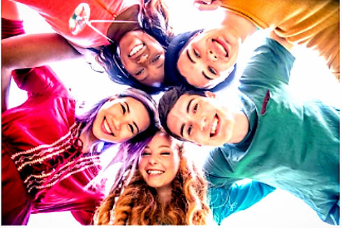 group of teens smiling with their heads together in a circle