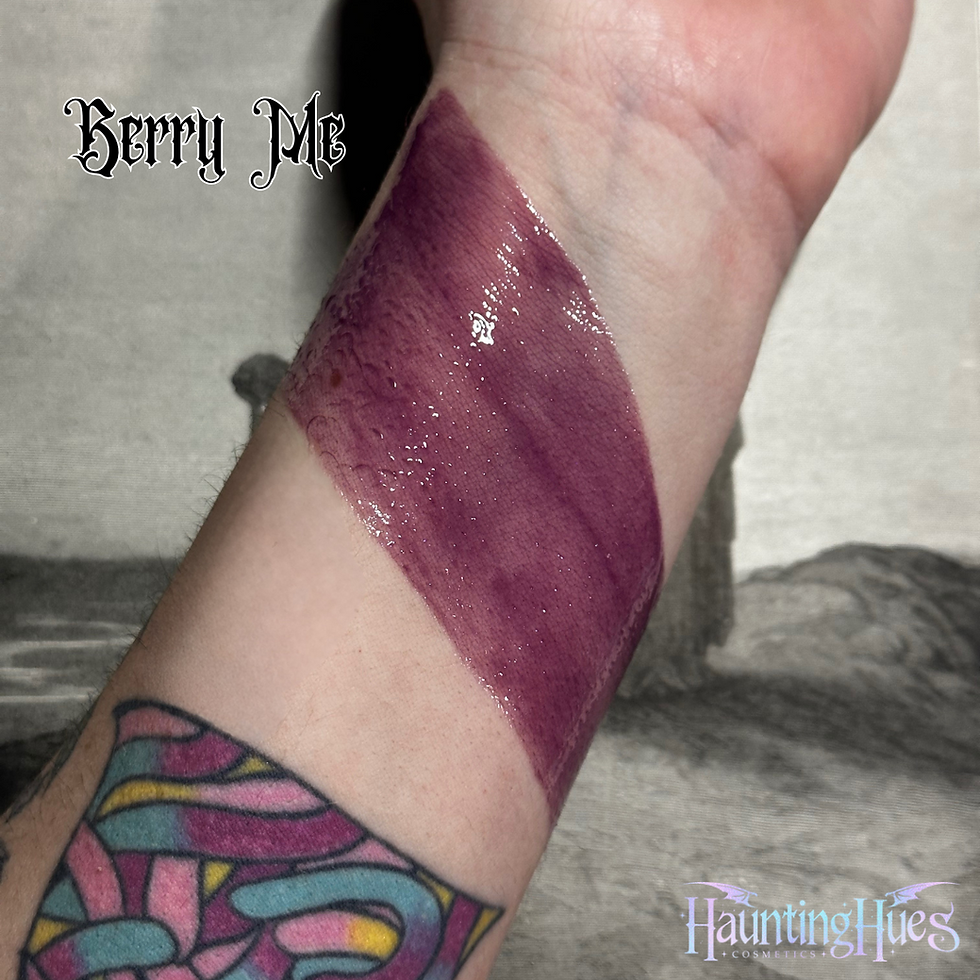 Wrist swatch shows 'Berry Pie' lipstick by Hunting Hues, with Morgue - Casket Contour Powder - Rice Powder.