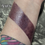 Thumbnail: Brujeria, swatch of Dark Matter - Sheer Berry Blue Shimmer Lip Gloss i on a wrist.