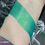 Thumbnail: Green eyeshadow swatch on wrist. Metallic shimmer, makeup product for eyes.