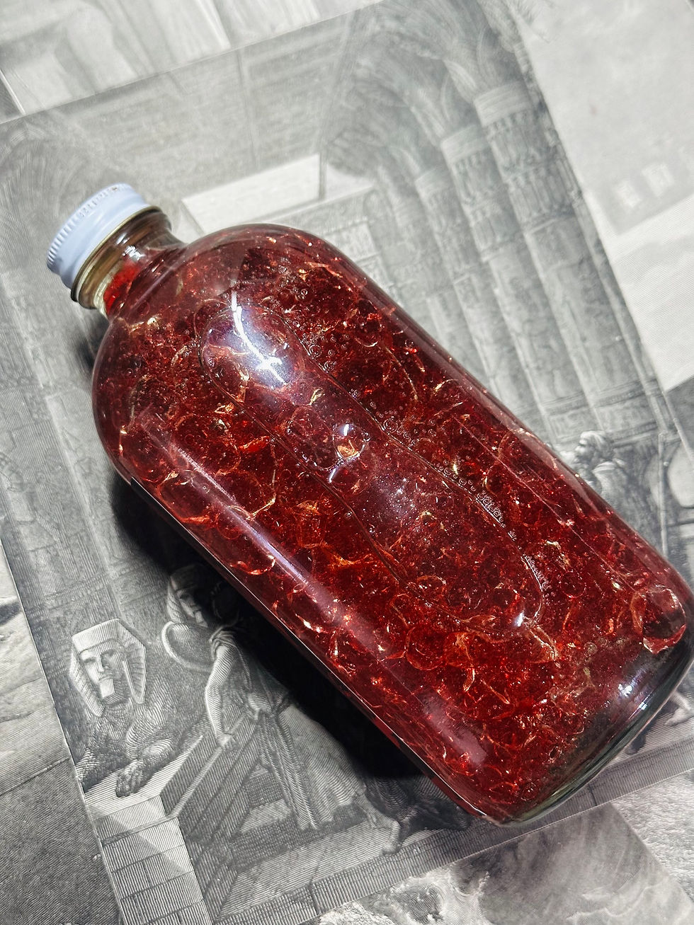 Thumbnail: Red liquid in a glass bottle on paper, detailed close-up shot.