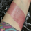 Thumbnail: Arm with shimmering pink swatch. Mourning Serum - 7% Copper Tripeptide and Hyaluronic Acid